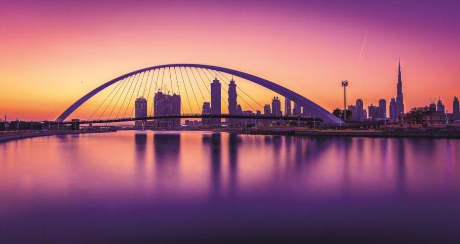 迪拜水渠-粉红色和紫色的色调与城市景观和桥梁